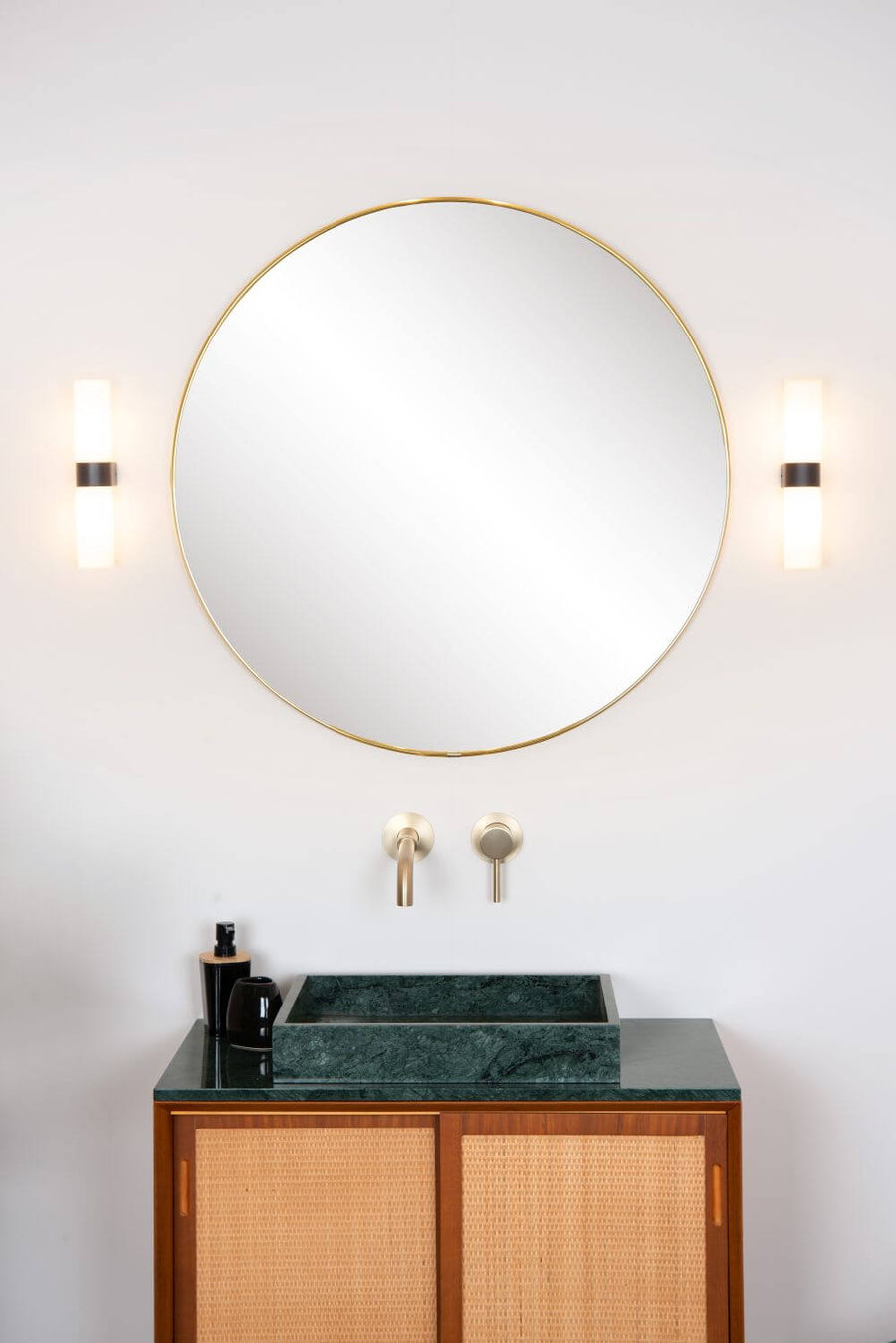 Produit de face, deux appliques cylindriques éclairées encadrant un miroir rond doré