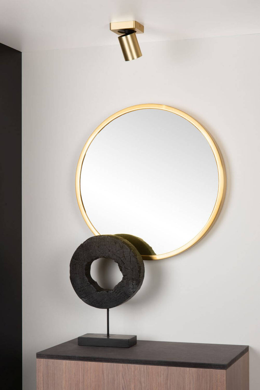 Vue de face du plafonnier doré fixé au plafond, entouré d'un miroir et d'une sculpture.