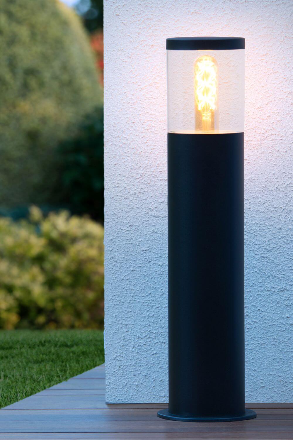 Mise en ambiance nocturne, borne éclairée contre un mur blanc texturé