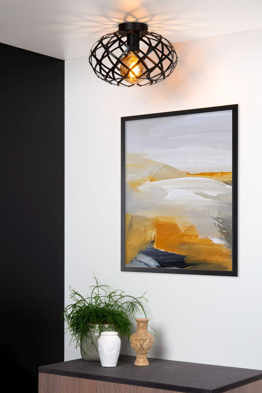Gros plan du plafonnier allumé, diffusant des motifs lumineux sur le plafond.