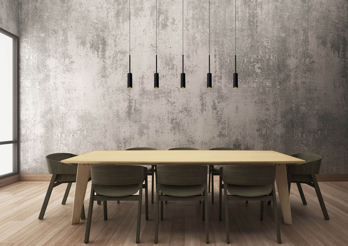 Mise en ambiance d'une salle à manger avec suspension noire linéaire au-dessus table claire