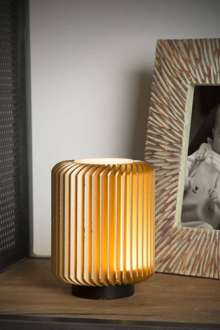 Vue rapprochée de la lampe allumée, mettant en valeur ses fines ailettes dorées.