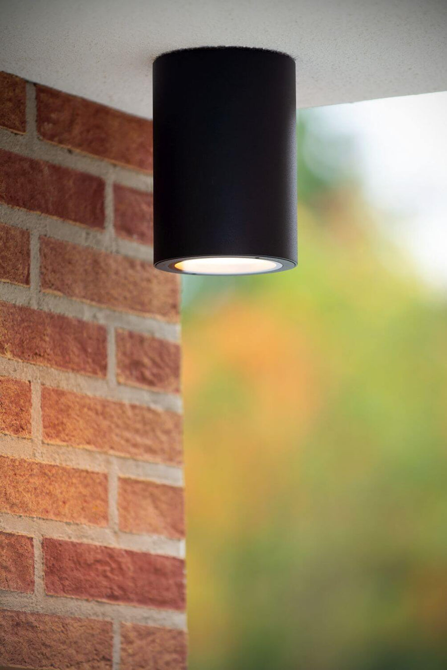 Vue rapprochée du luminaire allumé devant un mur de briques rouges