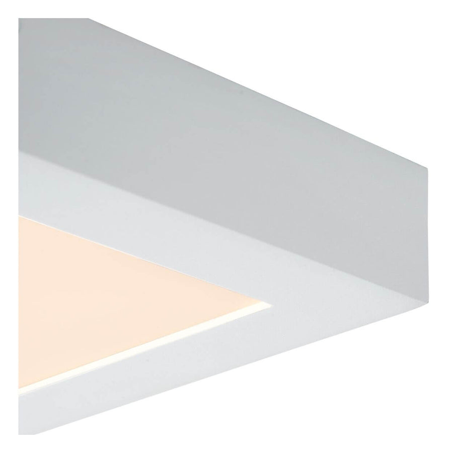 Détail de l'angle du cadre blanc et du diffuseur lumineux du plafonnier carré