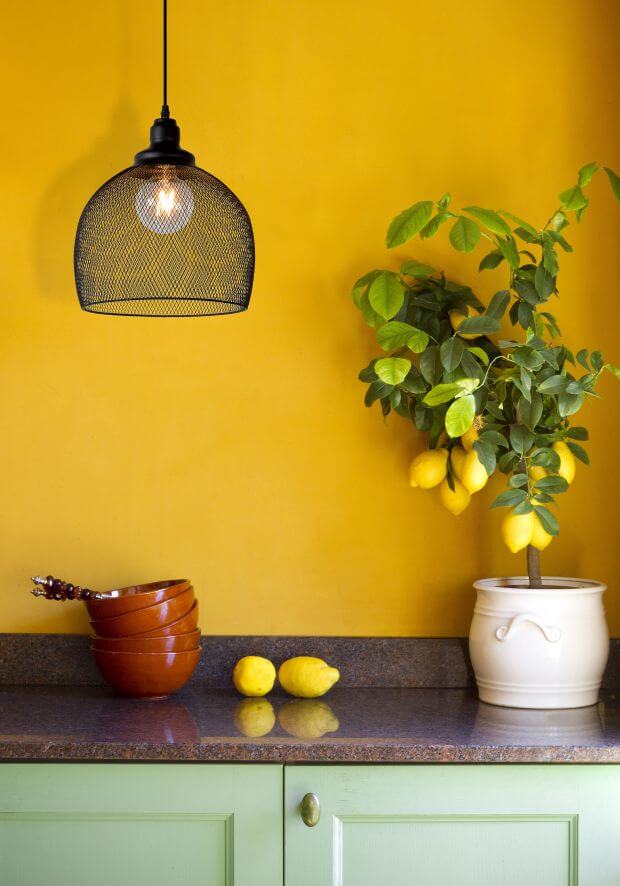 Vue de la suspension mesh noire dans une cuisine au mur jaune et citronnier