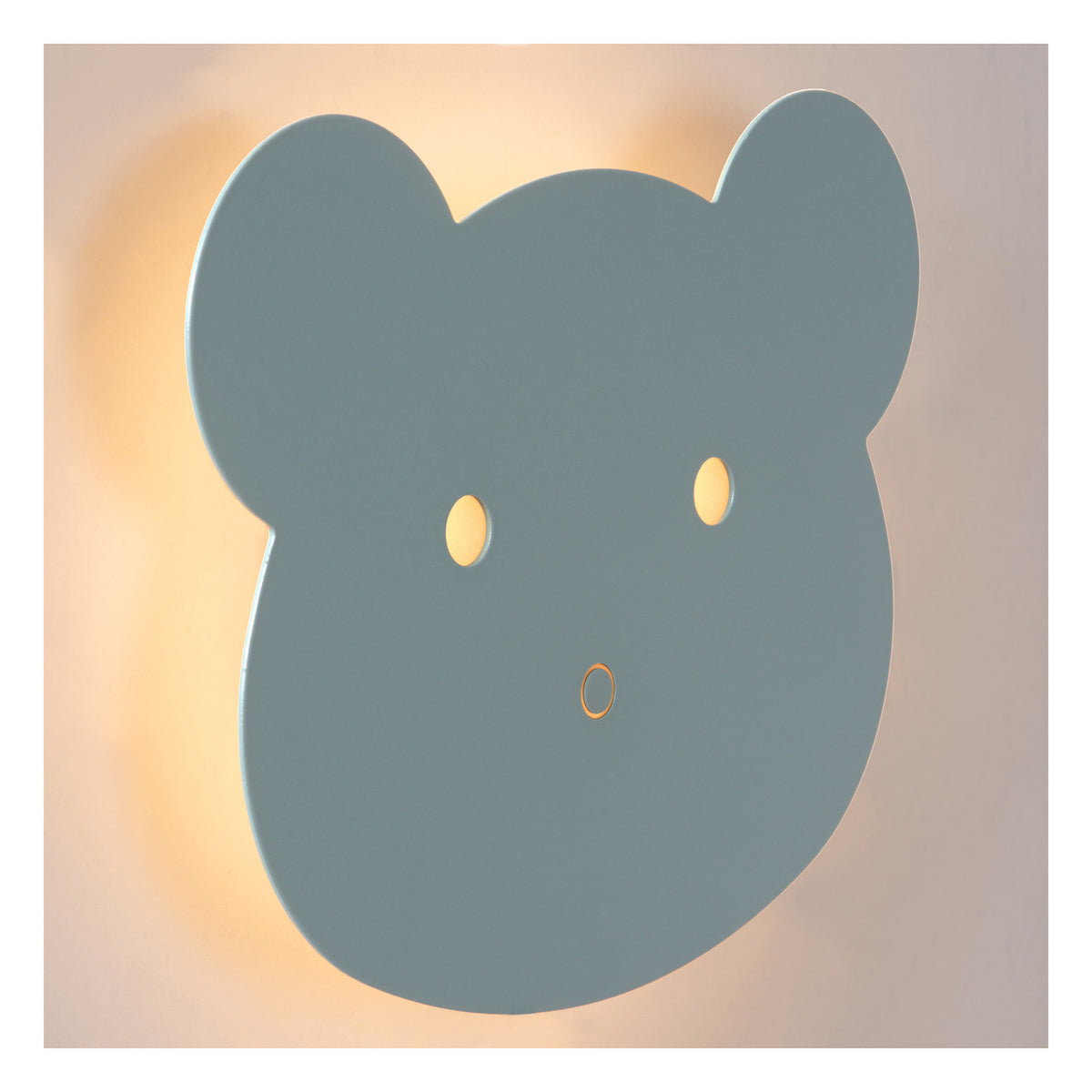 Gros plan sur la tête d'ours bleue de l'applique murale allumée, halo lumineux.