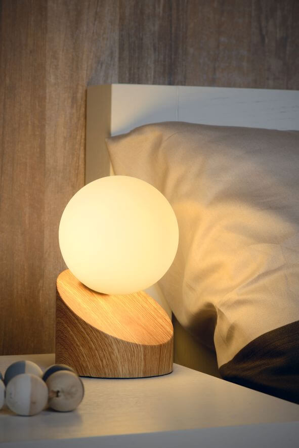 Vue rapprochée de la lampe éclairée, lumière douce sur les draps beiges