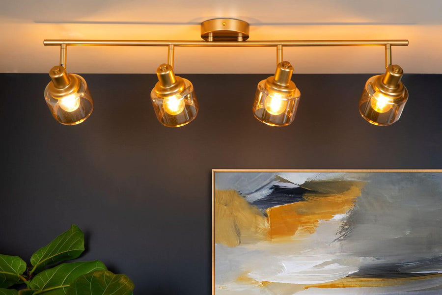 Vue rapprochée du luminaire doré fixé au plafond, avec ampoules allumées.
