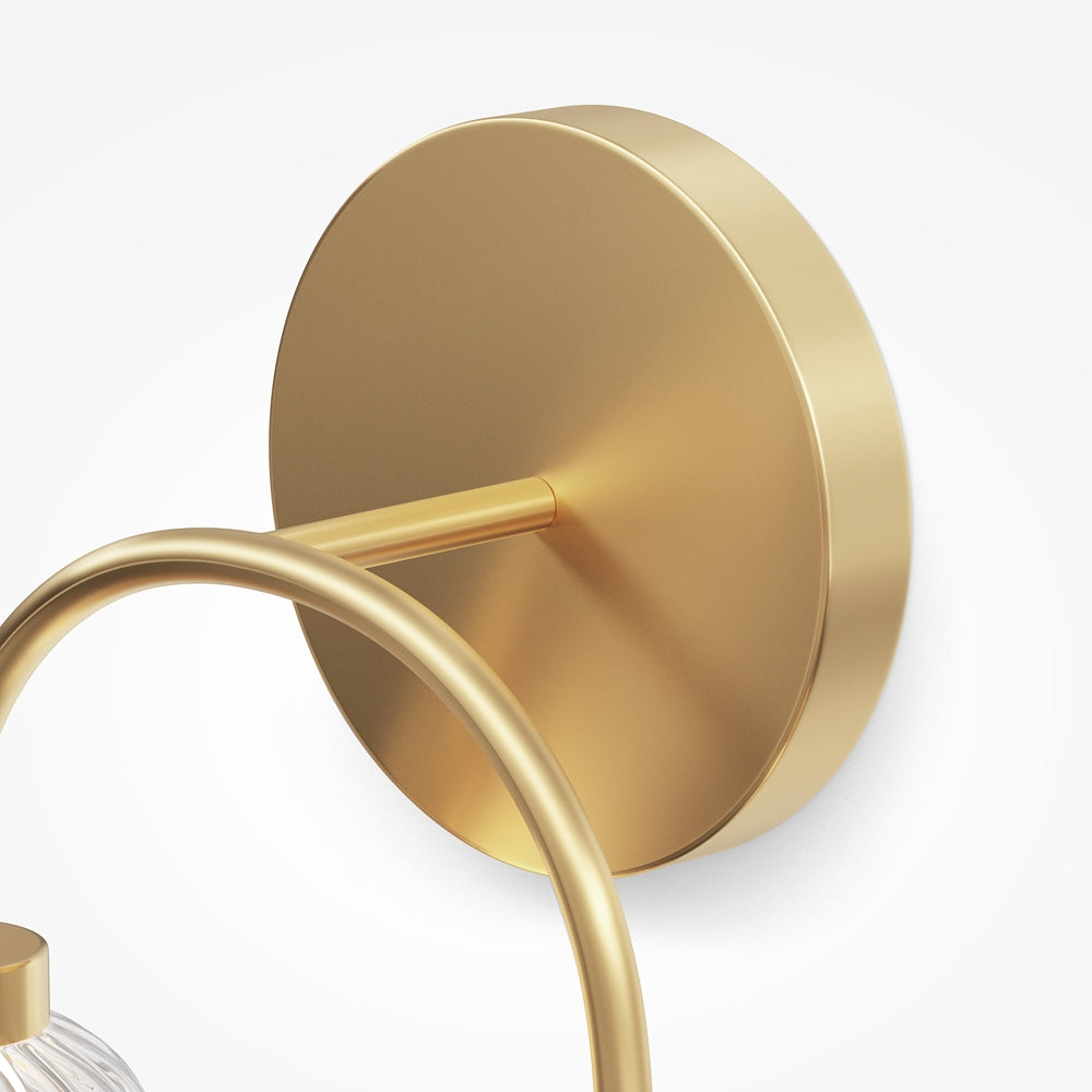 Détail de la platine ronde dorée et de son bras de fixation