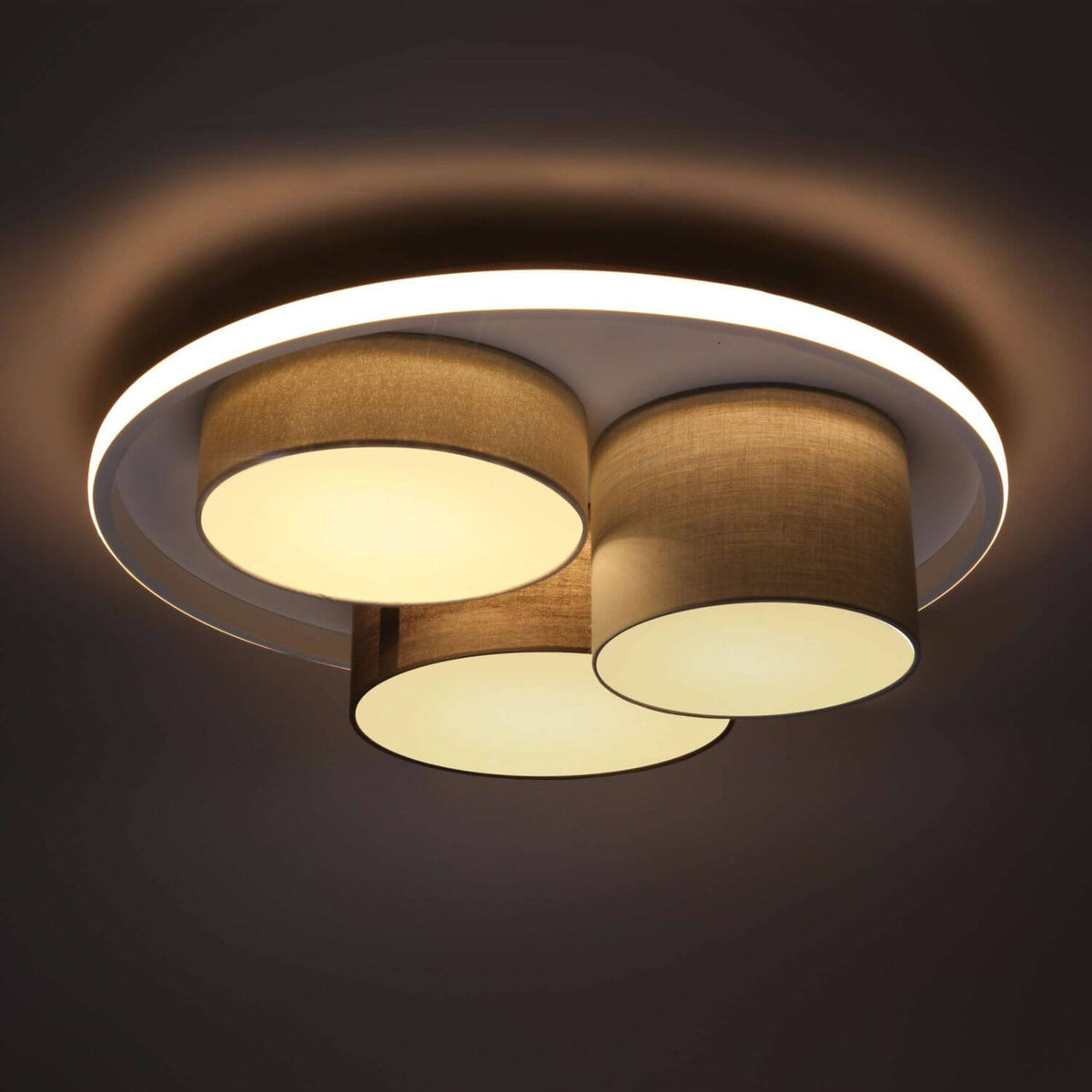 Luminaire allumé dans une pièce sombre, halo lumineux et diffuseurs circulaires éclairés