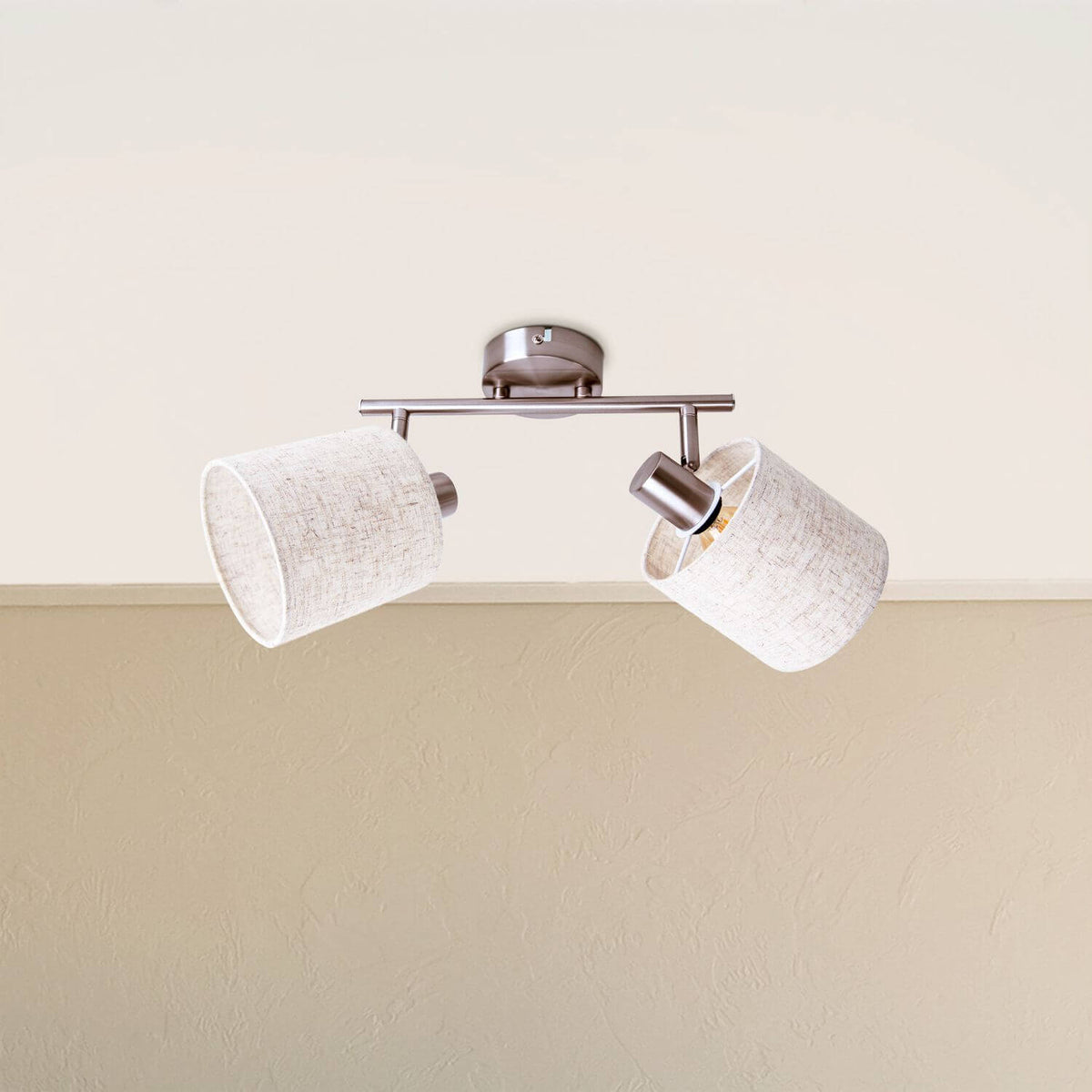 Plafonnier installé au plafond, deux abat-jours en tissu beige orientables, ambiance intérieure.