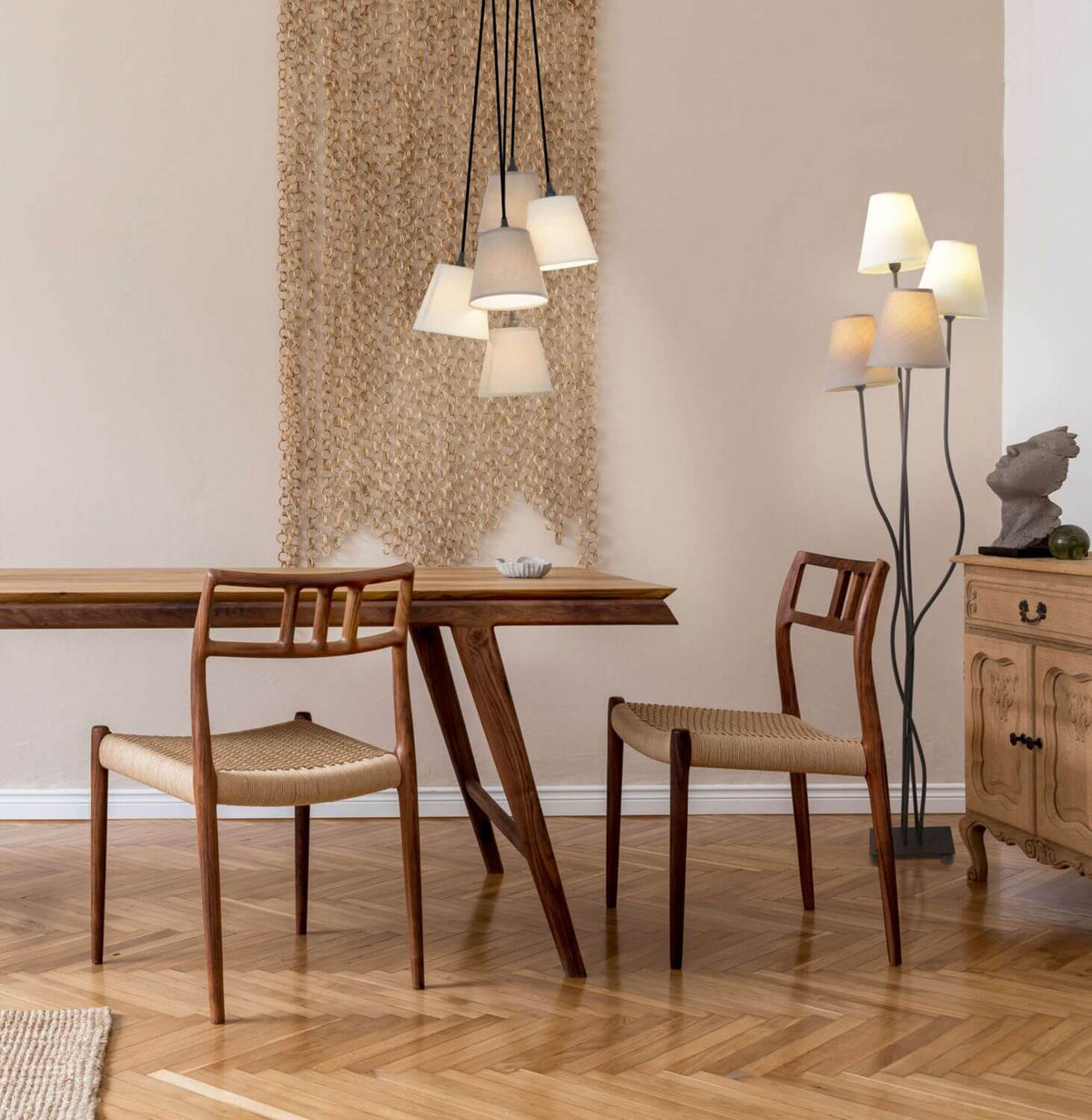 Lampadaire beige éclairé dans un intérieur avec suspension et meuble en bois