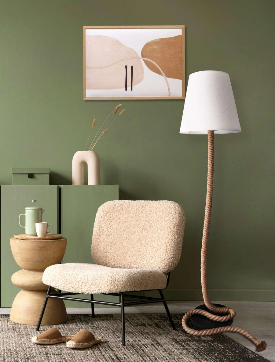 Ambiance intérieur vert, fauteuil bouclé, tableau abstrait et lampadaire allumé