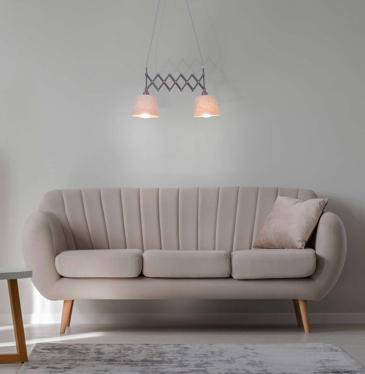 Suspension installée au-dessus d'un canapé beige dans un salon lumineux