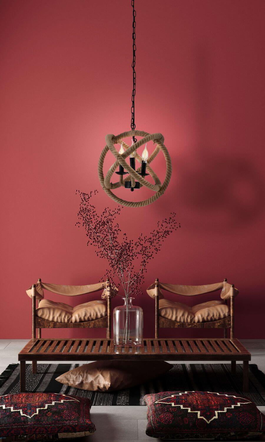 Photo d'ambiance sur fond rouge avec banc en bois et coussins à motifs.