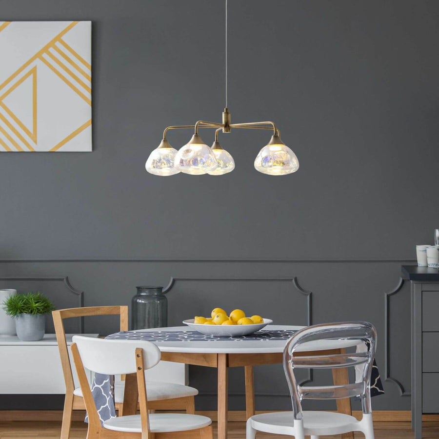Suspension allumée au-dessus d'une table ronde dans une salle à manger grise.