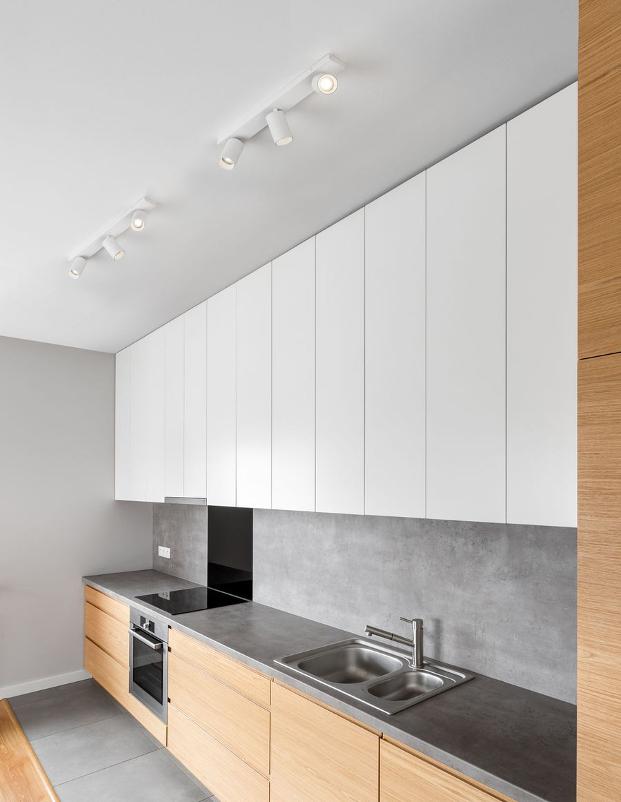 Plafonnier blanc fixé au plafond d'une cuisine moderne au-dessus du plan de travail
