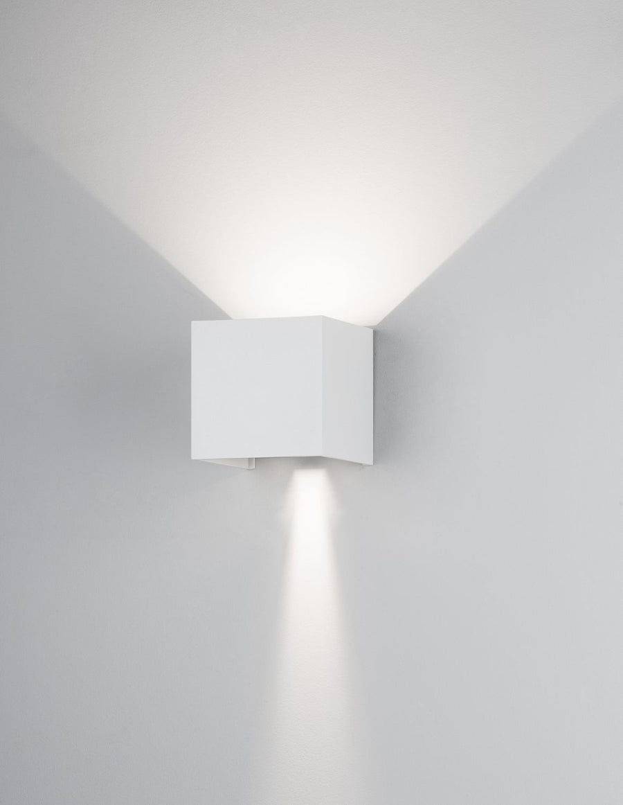 Applique carrée blanche allumée sur mur gris, halo haut et bas