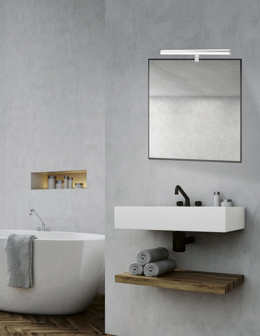 Applique chromée linéaire fixée au-dessus d'un miroir dans une salle de bain