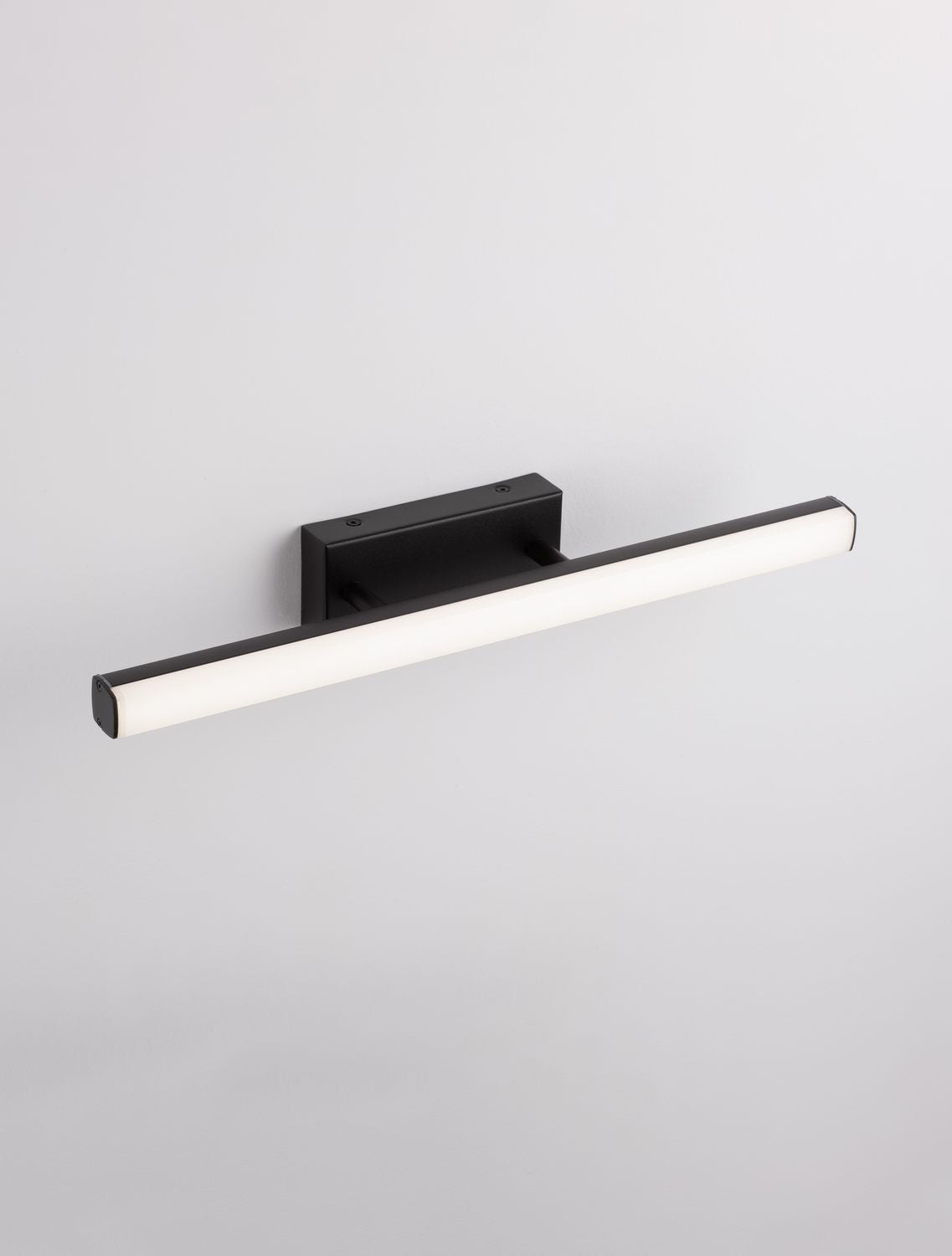 Autre angle du luminaire mural fixé sur un mur blanc uni