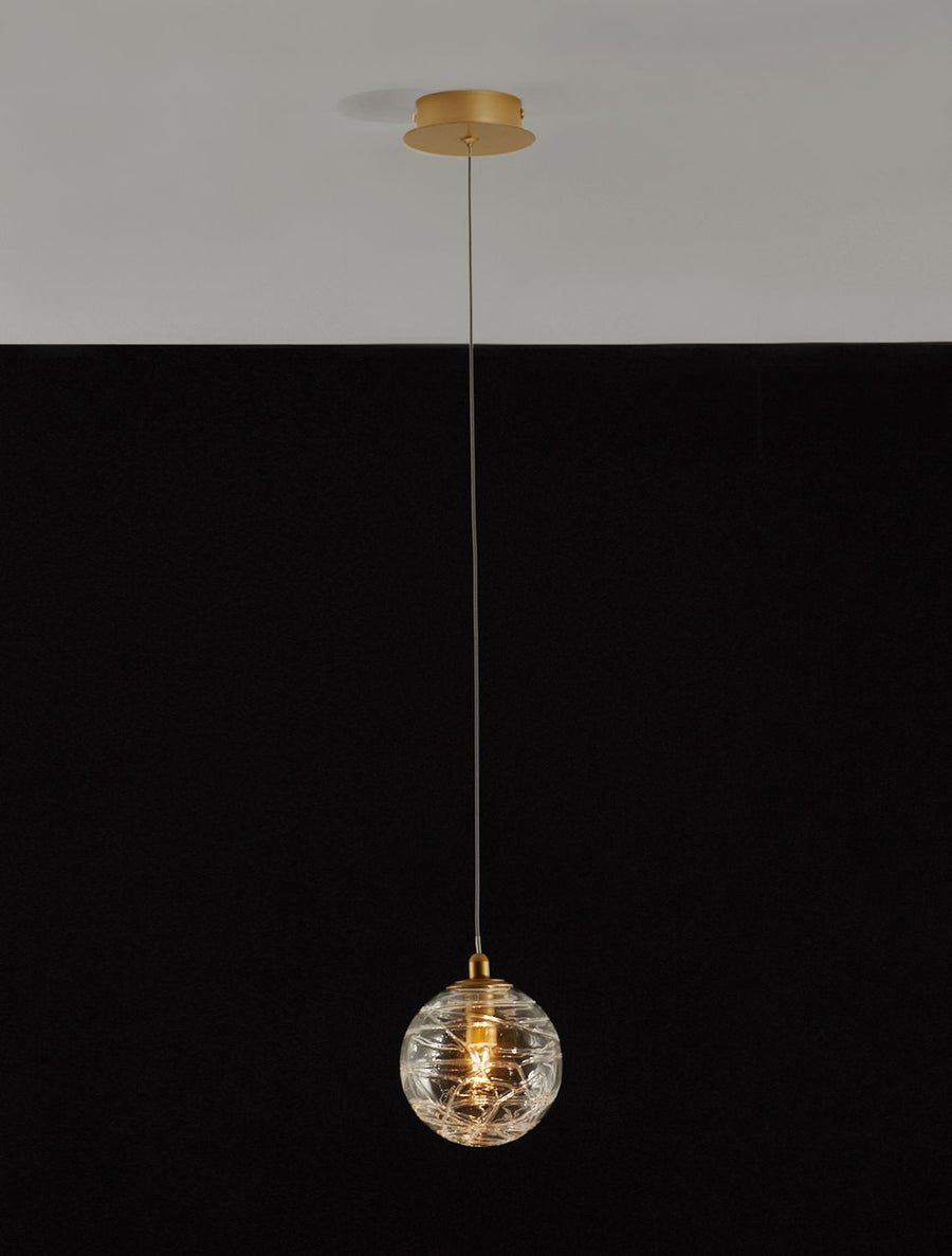 Suspension allumée sur fond noir, montrant l'ampoule et le motif du verre.