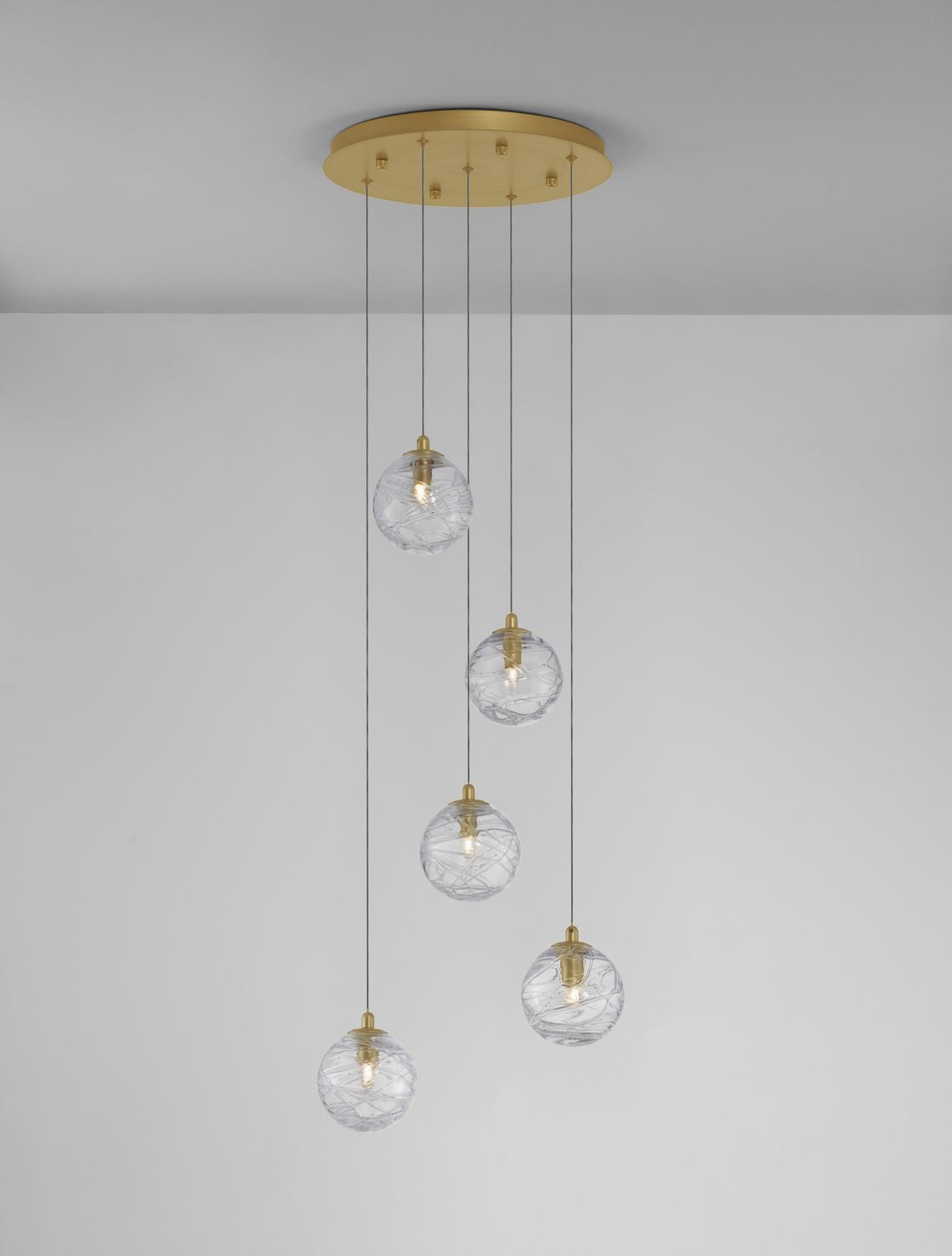 Globes de verre texturé allumés sous un plafond gris clair