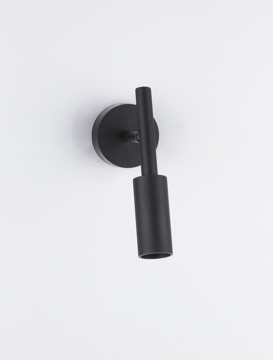 Luminaire mural noir présenté légèrement incliné, douille cylindrique et platine ronde