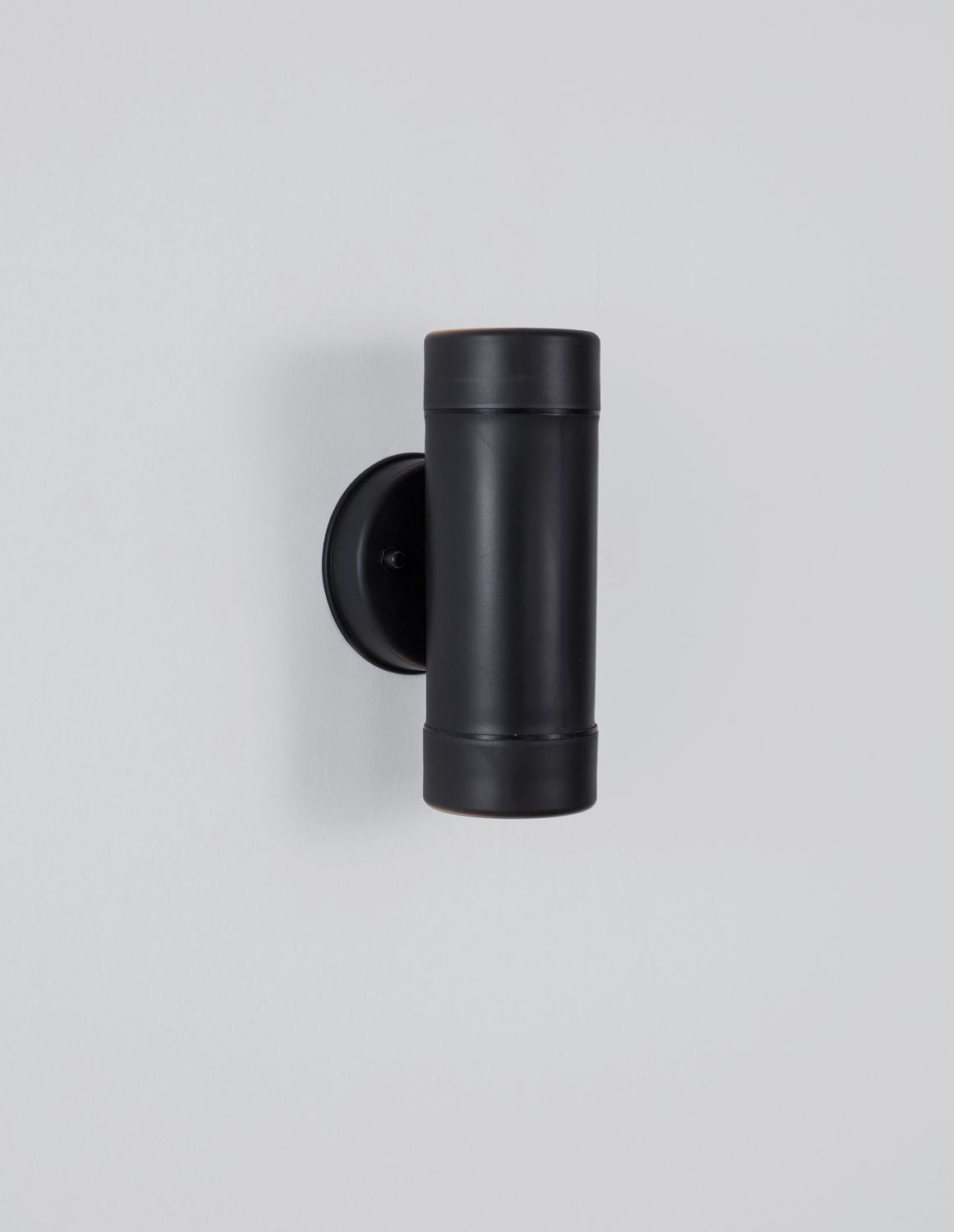 Produit de face sur fond blanc, cylindre noir mat et fixation murale