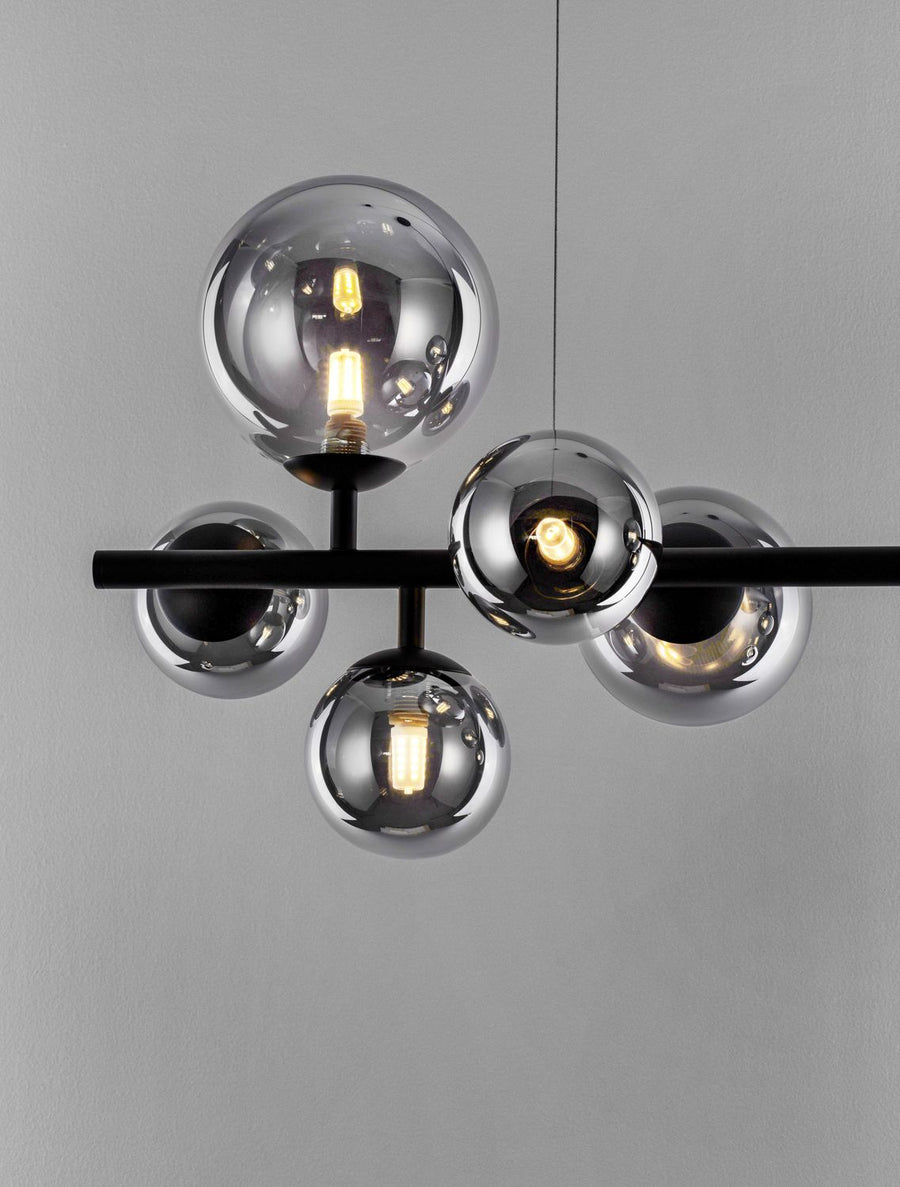 Zoom sur les ampoules LED filamenteuses logées dans les globes fumés