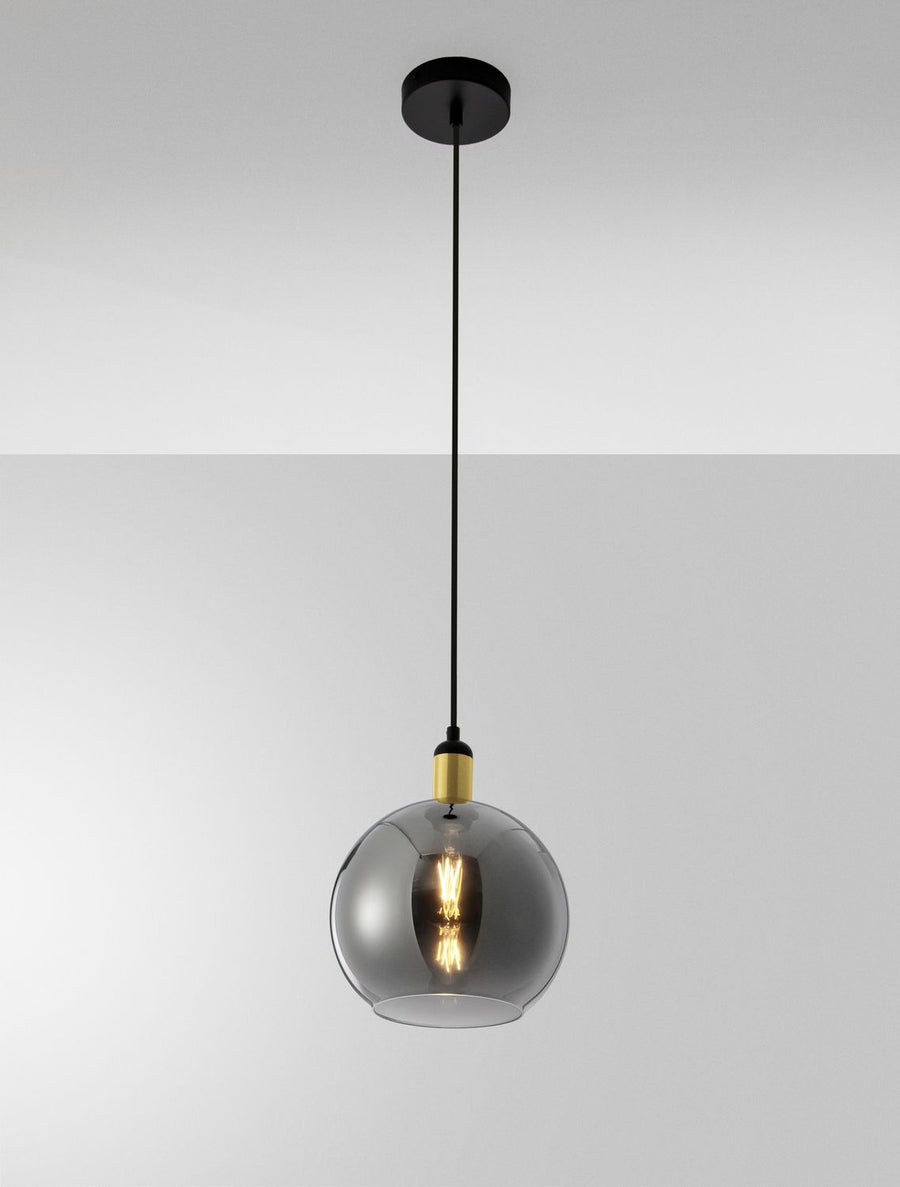Détail de la suspension éclairée montrant l'ampoule à filament doré à travers le verre