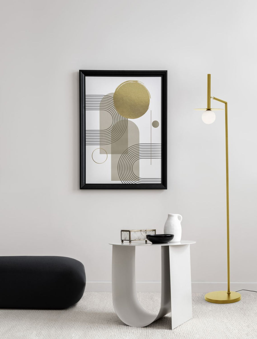 Lampadaire doré installé dans un salon minimaliste, près d'une table blanche