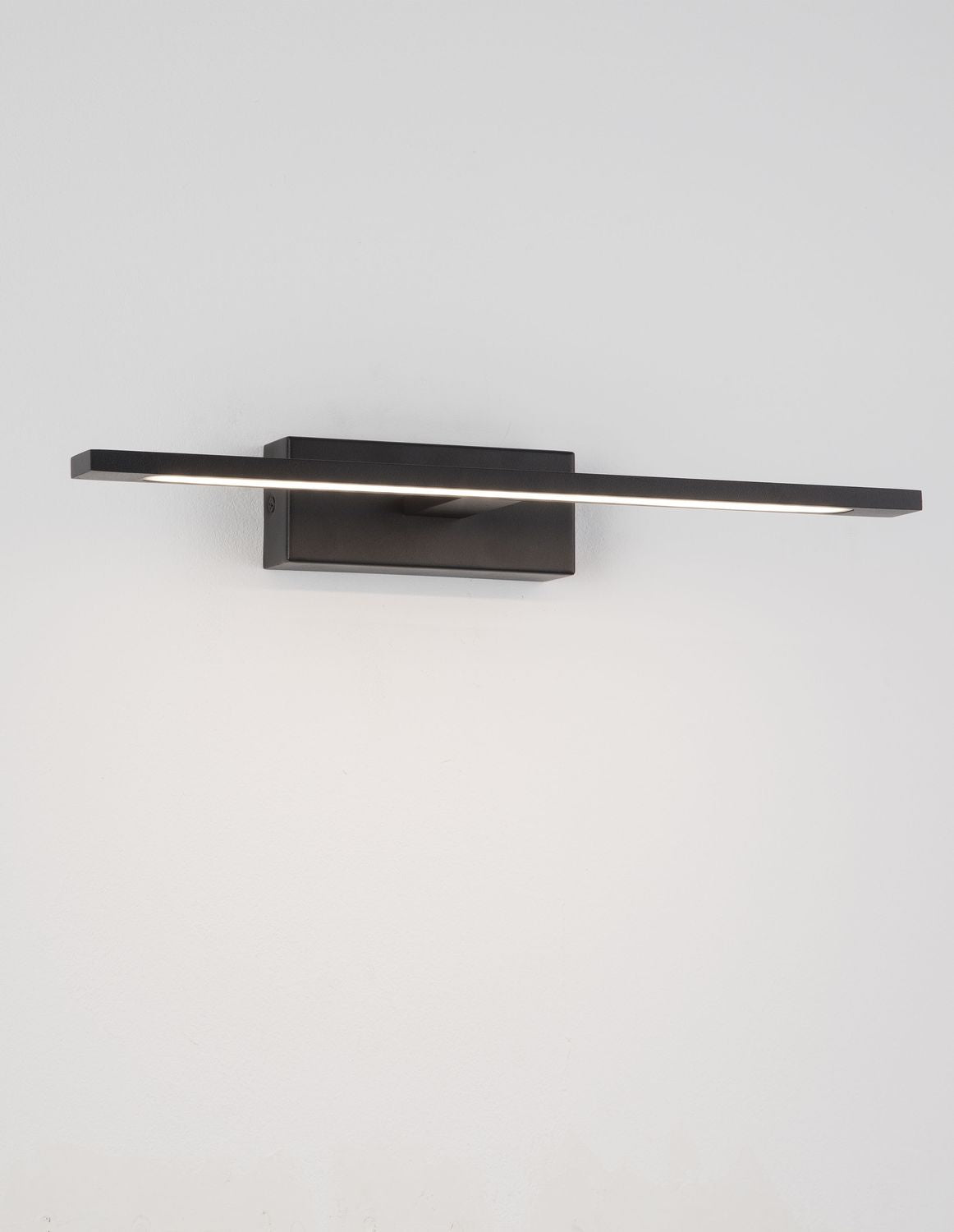 Applique murale noire vue de face, diffuseur LED allumé sous la barre.