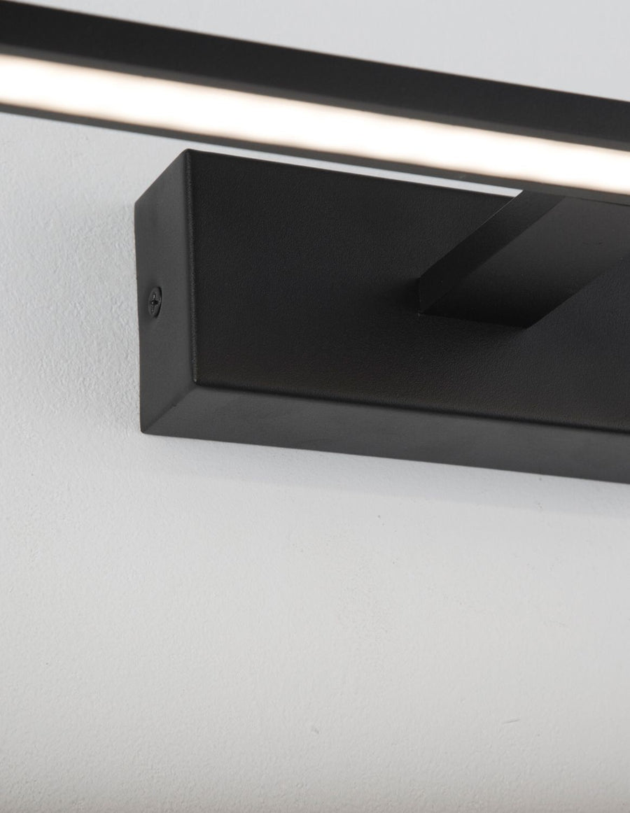 Détail du boîtier de fixation noir et de sa vis, finition mate épurée.