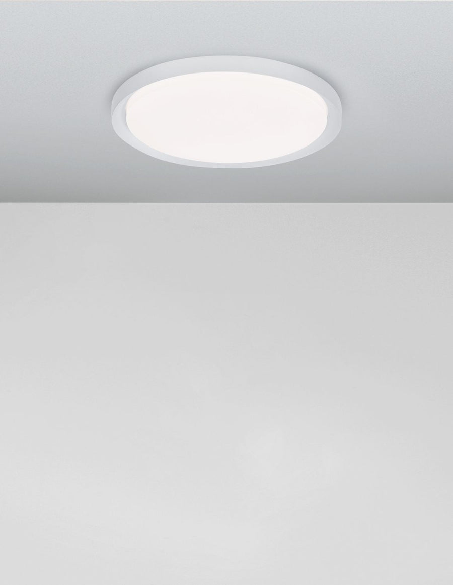 Plafonnier allumé au plafond diffusant une lumière blanche uniforme dans la pièce