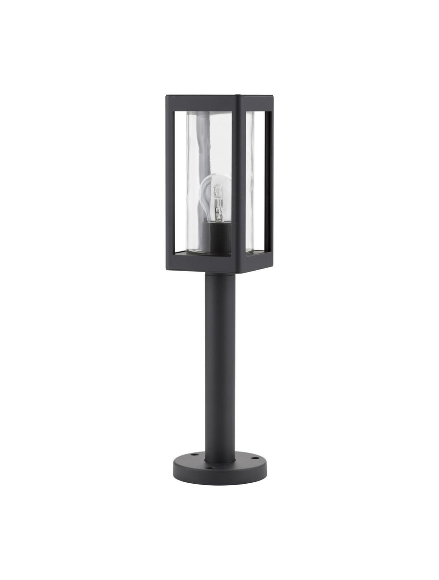 Vue de face du luminaire noir sur fond blanc, tête rectangulaire et verre cylindrique.
