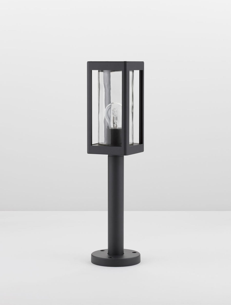 Autre vue du luminaire noir sur fond blanc, montrant le cadre métallique et le verre protecteur.