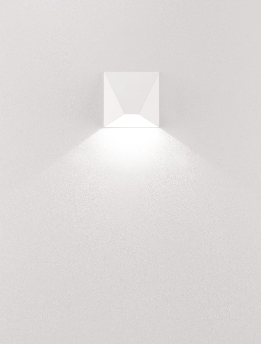 Luminaire blanc allumé projetant un cône de lumière vers le bas