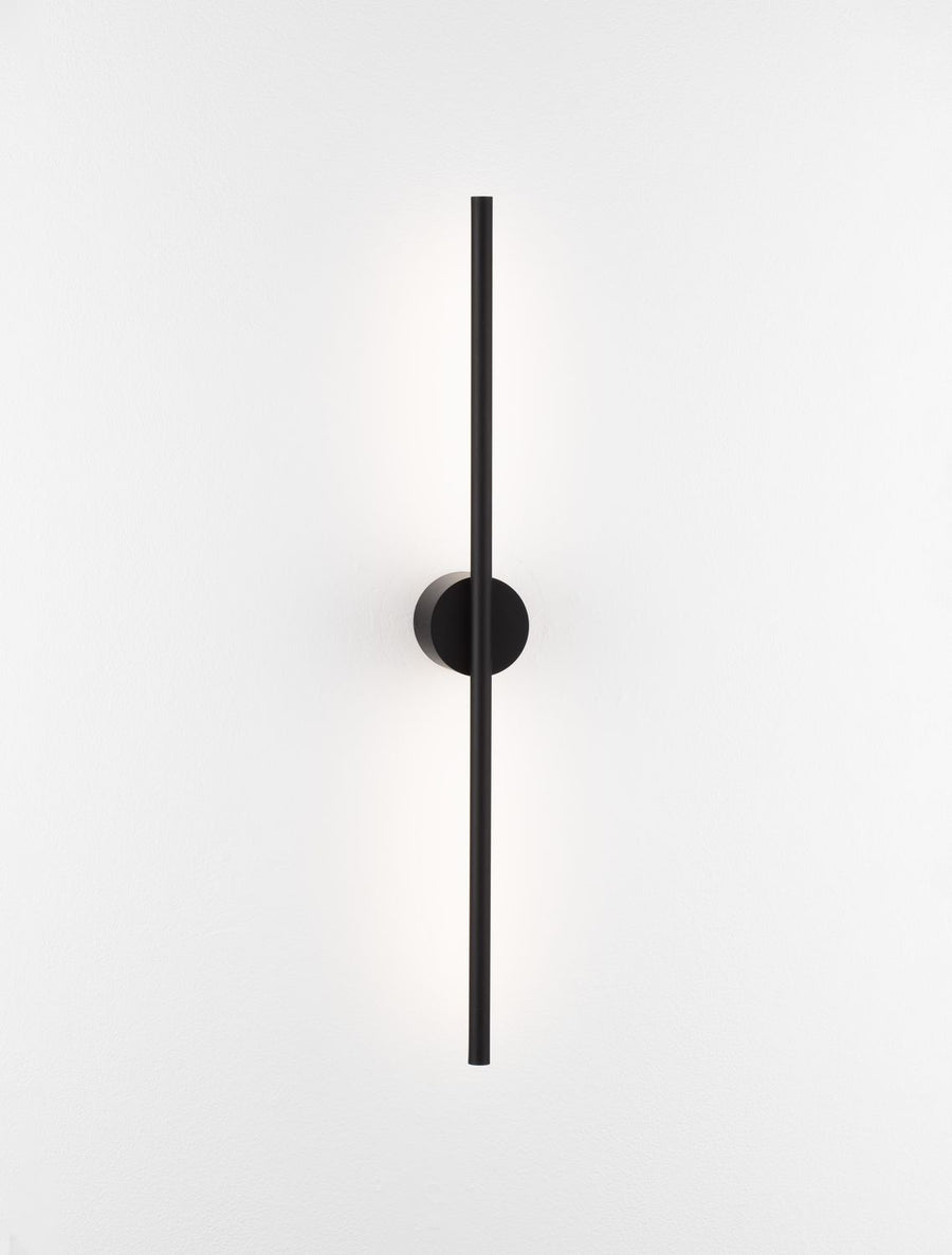 Luminaire entier de face, tige allumée émettant une lumière diffuse sur fond blanc