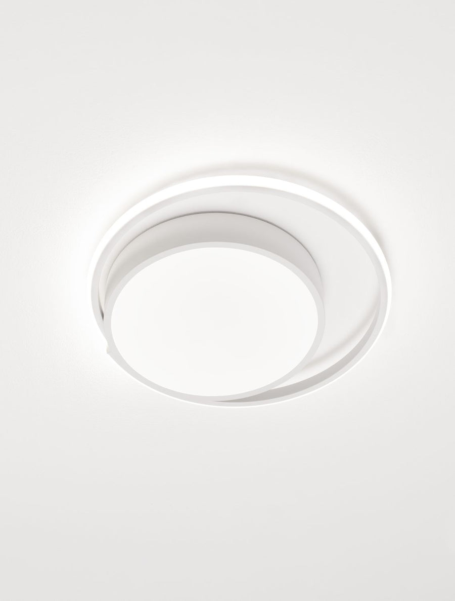Plafonnier blanc en fonctionnement diffusant une lumière douce au plafond.