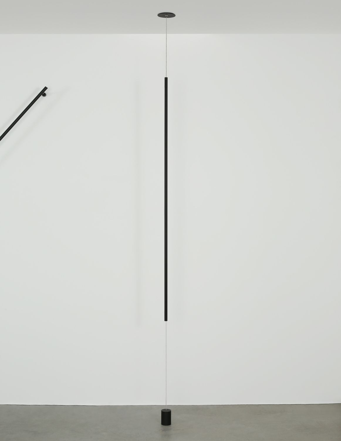 Mise en ambiance dans un intérieur blanc, suspension verticale noire allumée