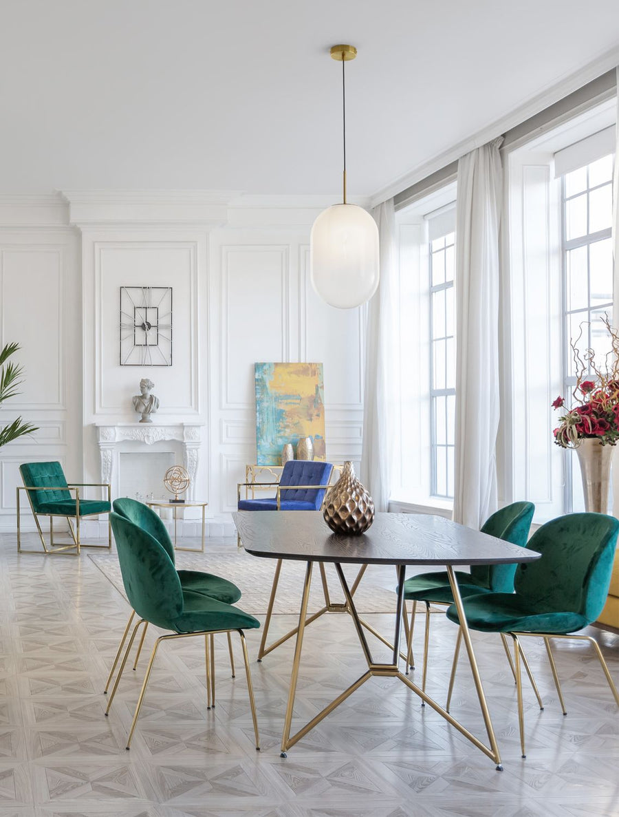 Suspension dorée allumée au-dessus d'une table dans une salle à manger contemporaine.