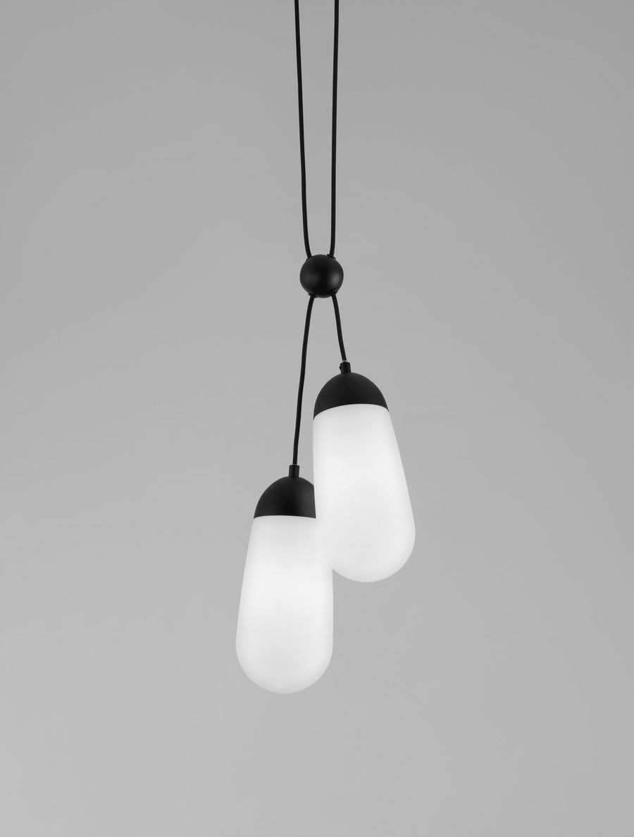 Détail des deux diffuseurs en verre blanc allumés, forme ovoïde et capuchon noir