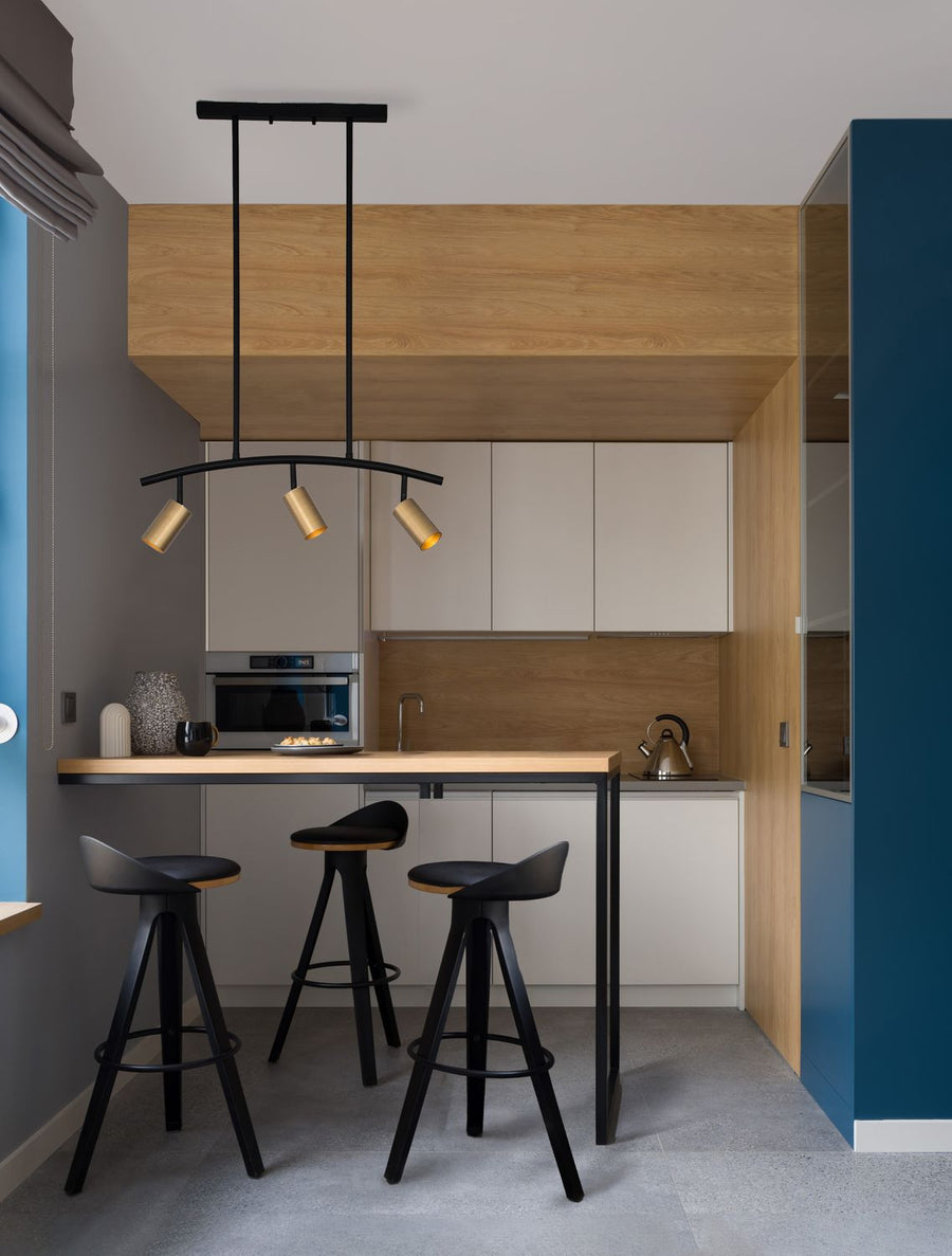 Suspension noire et dorée installée au-dessus d'un îlot de cuisine contemporaine