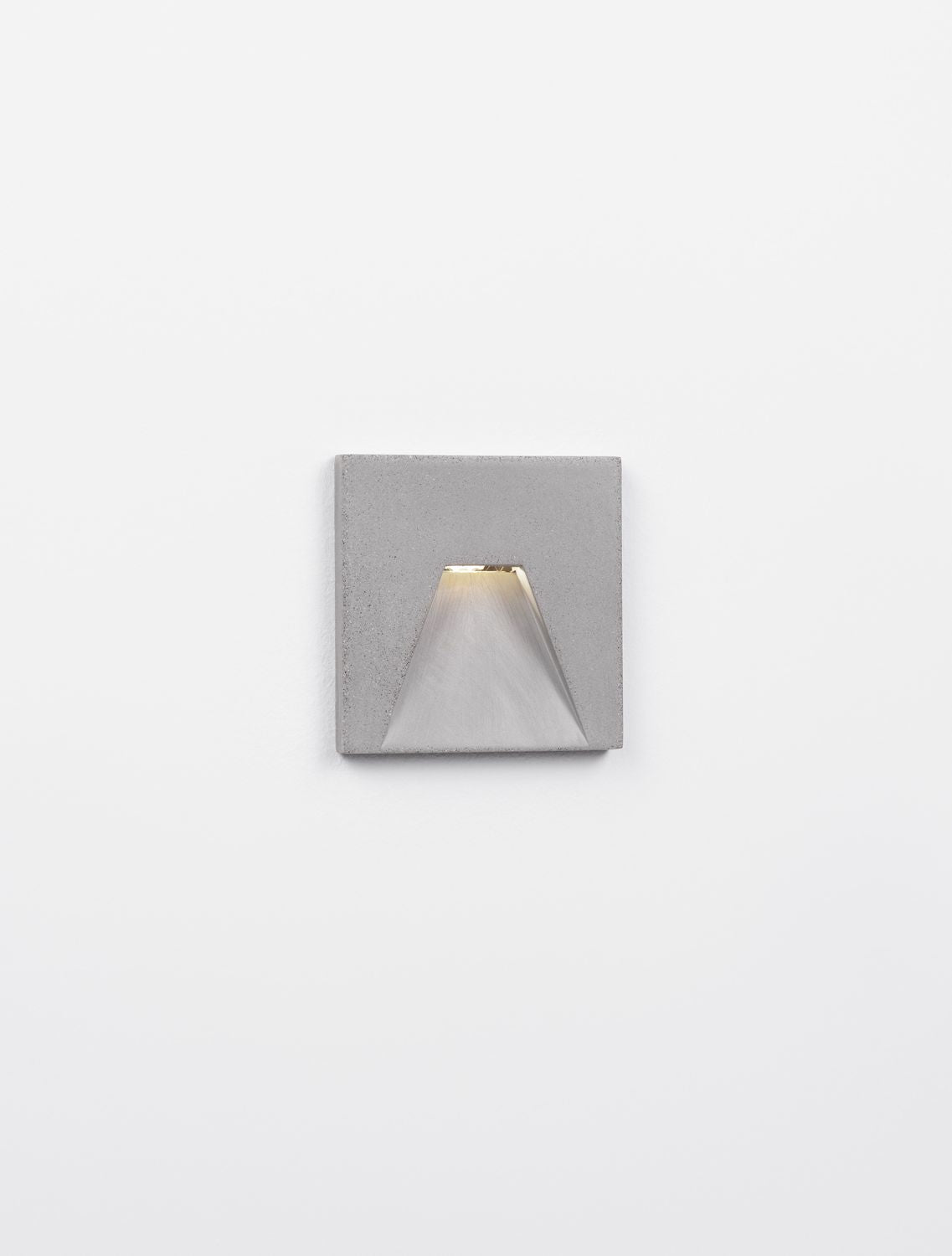 Applique allumée diffusant une lumière chaude vers le bas, fond neutre