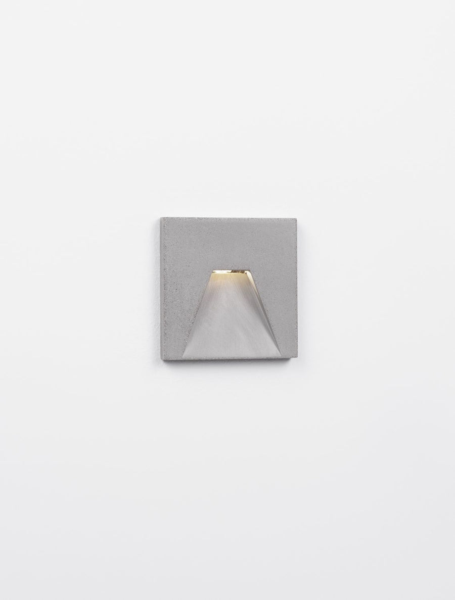 Applique allumée diffusant une lumière chaude vers le bas, fond neutre
