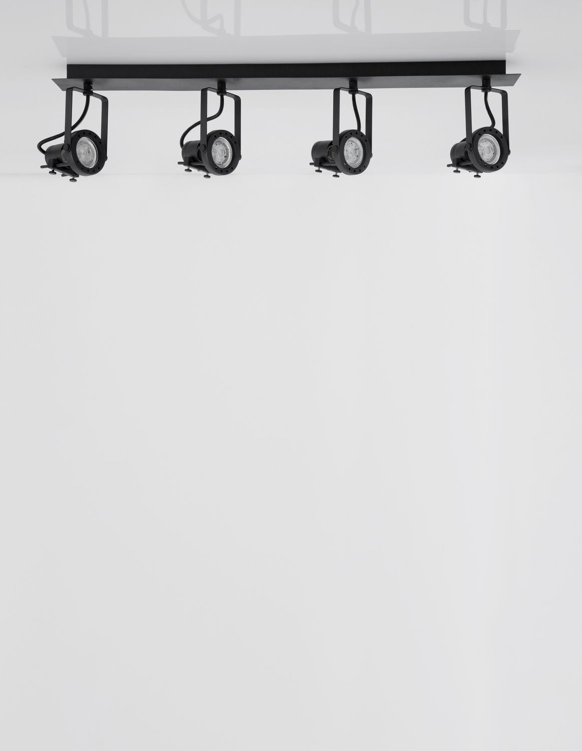 Vue de dessous du luminaire, quatre spots noirs fixés sur rail rectangulaire