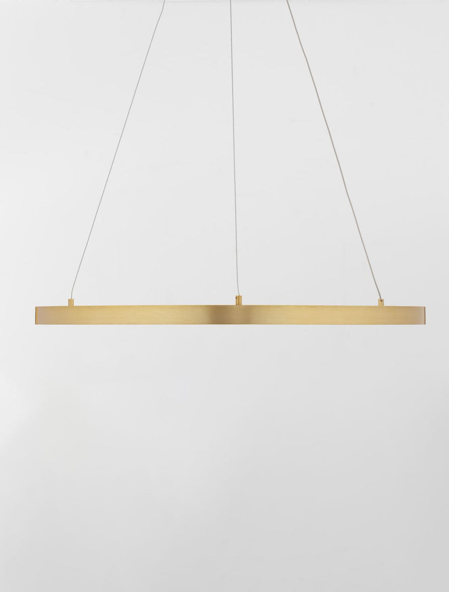Barre lumineuse dorée horizontale suspendue par trois câbles fins sur fond neutre