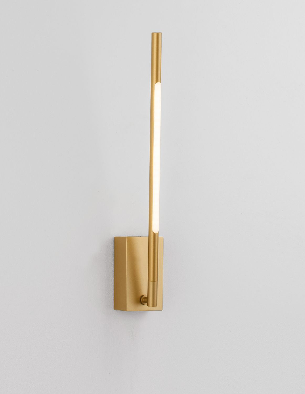 Luminaire mural allumé, long tube diffusant une lumière blanche chaude le long du mur