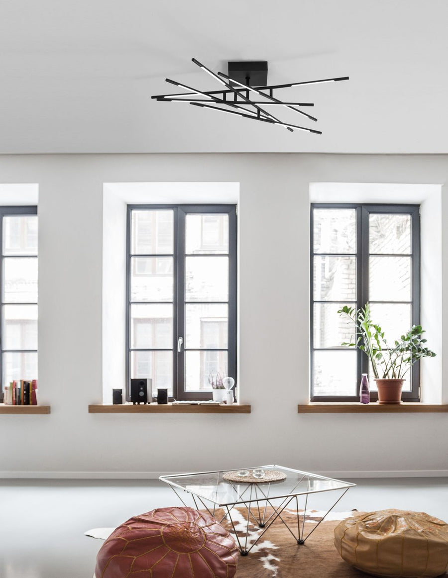 Plafonnier noir fixé au plafond dans un salon clair aux murs blancs