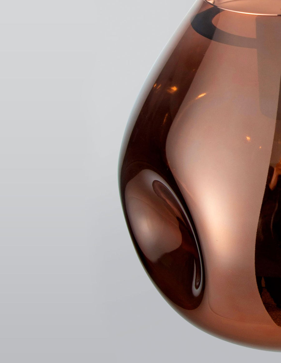 Détail du verre cuivré brillant avec reflets et ombres de la pièce.